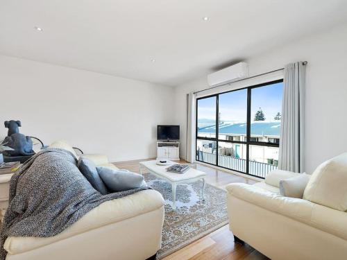 a living room with a couch and a large window at PROVINCIAL ON PASCOE - everything at your doorstep in Apollo Bay