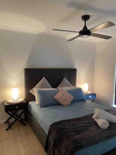 a bedroom with a bed with a ceiling fan at A Wave from It All Esperance in Esperance
