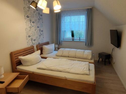 a bedroom with two beds and a window at Klütz Semi-Detached House, 2 Double Beds, 2 Single Beds in Klütz