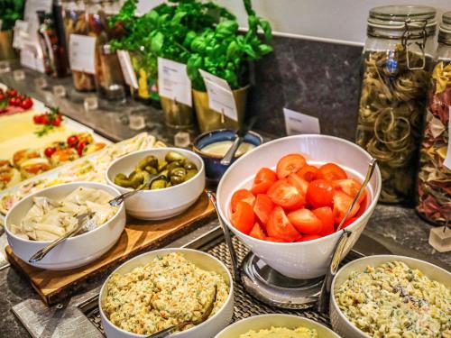 a buffet with bowls of different types of food at Novotel Poznań Malta in Poznań