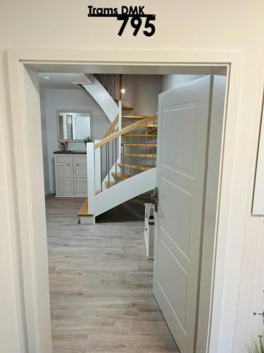a hallway with a white door and a staircase at Komfort-Doppelhaus, 3 Schlafzimmer, Jesendorf in Jesendorf