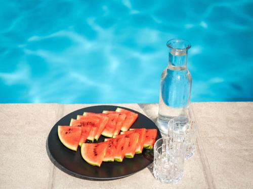 two slices of watermelon on a plate next to a bottle at Ibis Styles Linz in Linz