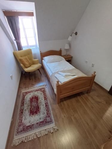 a bedroom with a bed and a chair and a window at Hotel Salamander - Garni in Banská Štiavnica