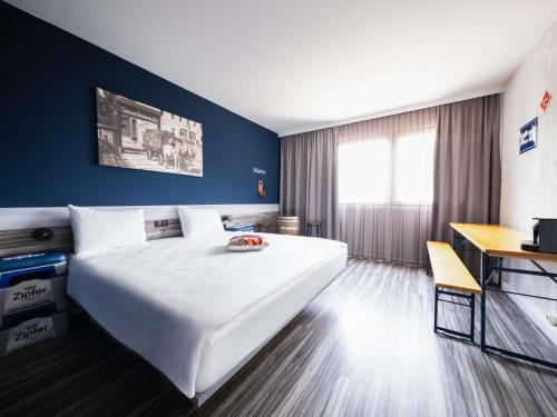a hotel room with a large bed and a desk at Ibis Styles Linz in Linz