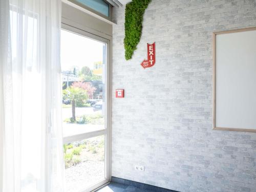 a window with a sign on a brick wall at Ibis Styles Linz in Linz