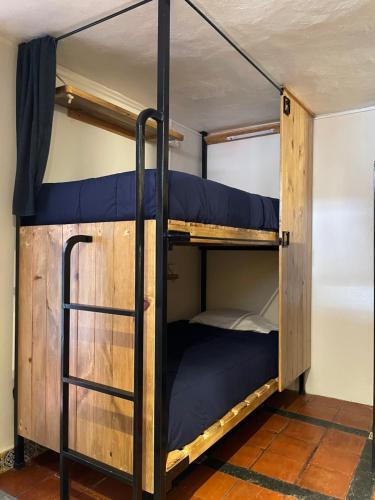 a bunk bed with blue pillows in a room at Hostal La Isla in San Cristóbal de Las Casas