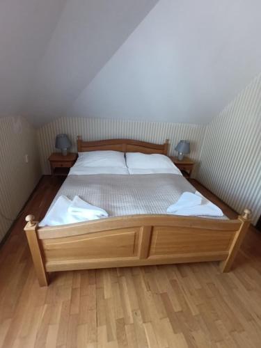 a bedroom with a wooden bed with two night stands at Hotel Salamander - Garni in Banská Štiavnica