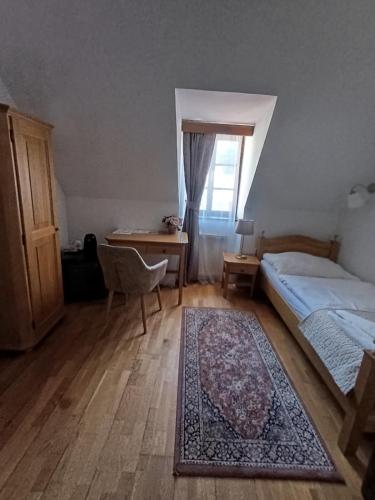 a bedroom with a bed and a desk and a window at Hotel Salamander - Garni in Banská Štiavnica