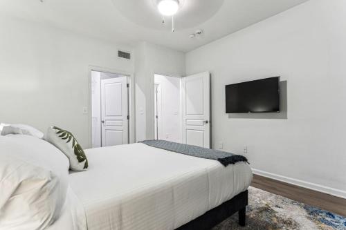 una camera da letto bianca con un letto e una TV a schermo piatto di Suite Life in Frisco, Luxury meets Comfort a Frisco