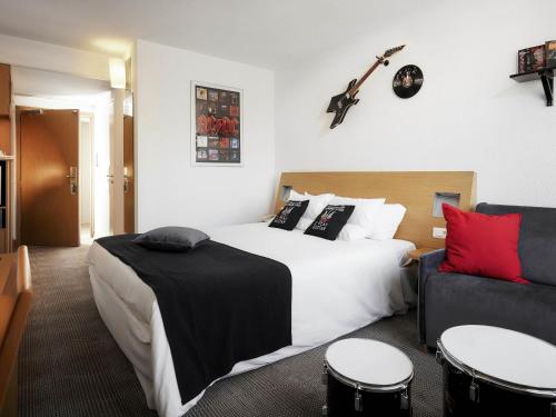 a hotel room with a bed and a guitar on the wall at Novotel Gdansk Centrum in Gdańsk