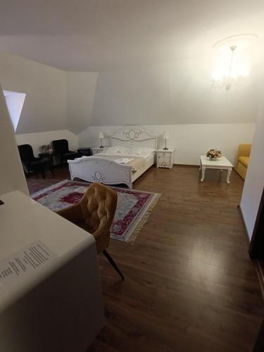 a white room with a bed and a chair at Hotel Salamander - Garni in Banská Štiavnica