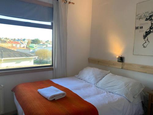 a bedroom with a bed with two towels on it at Hain Casa Hotel in Punta Arenas