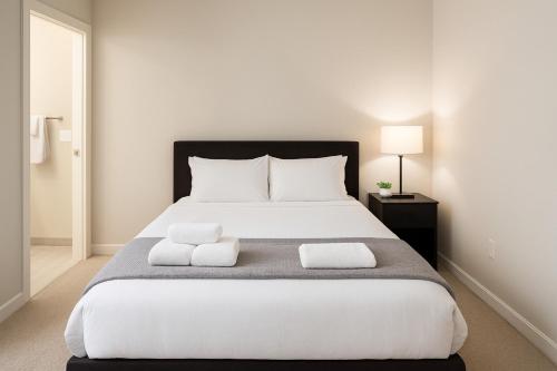 a bedroom with a large white bed with two pillows at Stylish Luxe Suite Rock Hall, Stadiums, Casino in Cleveland
