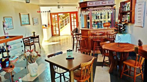 a restaurant with tables and chairs and a bar at Alpenhaus Pousada in Campos do Jordão