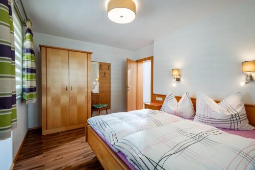a bedroom with a bed and a wooden cabinet at Apartmenthaus Stefan in Hippach