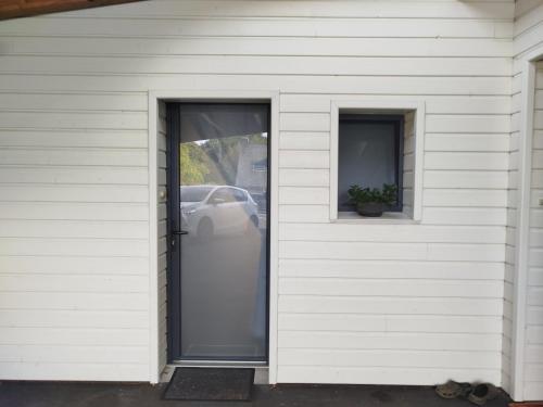 een wit huis met een deur en twee ramen bij Les hortensias in Lannion