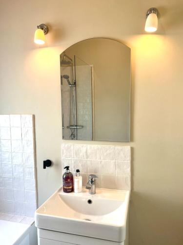 a bathroom with a sink and a mirror at Chic Welsh Escape Character Home in Newport