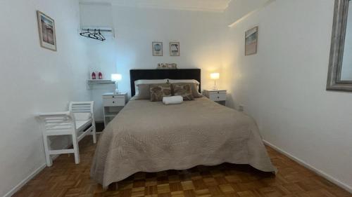Un dormitorio con una cama grande y una silla. en Botanico&Soho, en Buenos Aires