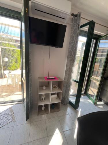a living room with a flat screen tv on the wall at VillettaletreGi SELF-CHECK-IN in Campofelice di Roccella