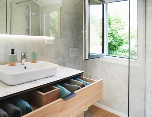 a bathroom with a sink and a mirror at Modernes Familien Tiny House - Natur & Sternenhimmel inklusive! in Untergriesbach