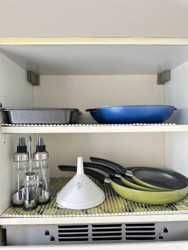 a shelf with bowls and utensils in a kitchen at Casa vacanze da Piera di Carta Giuseppina in Sassari