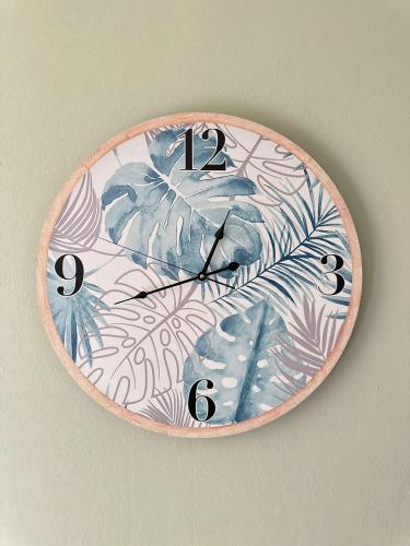 a clock on a wall with plants on it at Casa vacanze da Piera di Carta Giuseppina in Sassari
