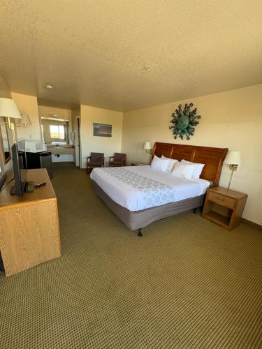 ベンソンにあるCopper Stay Inn - Rodeway Inn Benson AZ I-10 Exit 304の大きなベッドと薄型テレビのある寝室