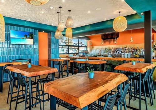 un ristorante con tavoli in legno e sgabelli da bar di Serenity@TheBlyde a Pretoria