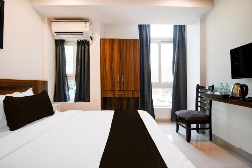 a hotel room with a bed and a chair at Super Collection O Sayhallo Narcos in Bhubaneshwar