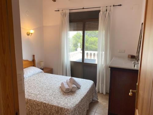 a bedroom with a bed with towels on a table at Villa con encanto en Benimarco in Paratella
