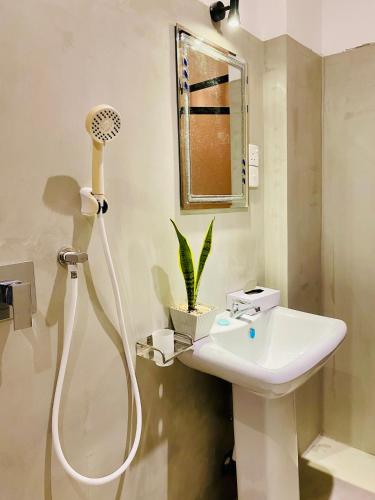 a bathroom with a white sink and a shower at TIKITIBE Villa & Restaurant in Hiriketiya