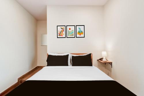 a bedroom with a large bed with two pictures on the wall at Hotel O Holiday Luxury in Hyderabad