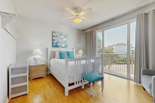 Biała sypialnia z łóżkiem i balkonem w obiekcie High Pointe 235 w mieście Rosemary Beach