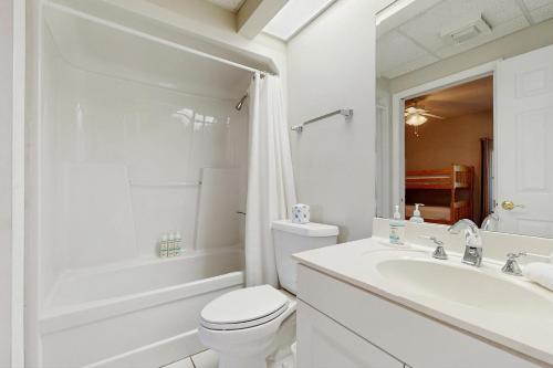 biała łazienka z toaletą i umywalką w obiekcie High Pointe 235 w mieście Rosemary Beach