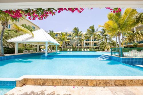a large swimming pool with palm trees and a building at 2 Bdrm Stunning Marina View at The Yacht Club C5 in Providenciales