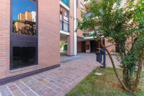 a brick building with a tree next to a building at La casetta in Castel Maggiore