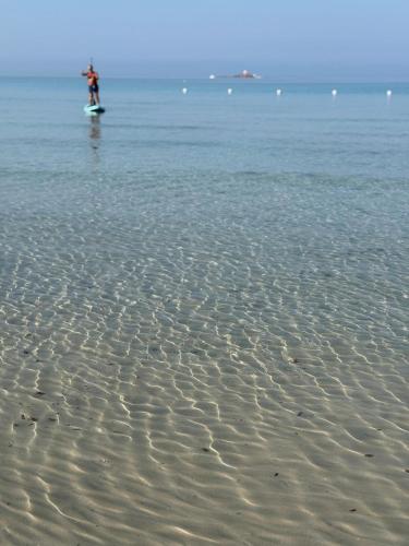 a person standing on a surfboard in the water at Casa MaJe in Olmedo