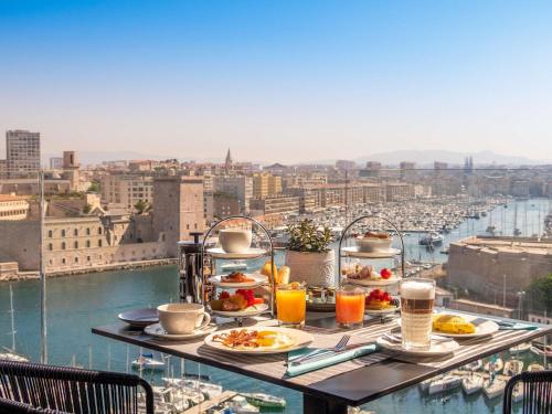 a table with plates of food on top of a city at Sofitel Marseille Vieux-Port in Marseille