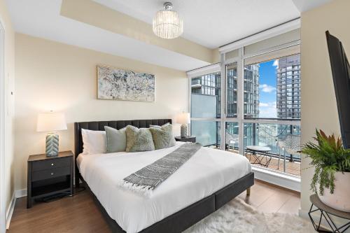 a bedroom with a large bed and a large window at Ultra Luxurious 2.5 Bedroom 2 Full Bathroom 1 Parking Condo Near SQ1 Striking Views in Mississauga