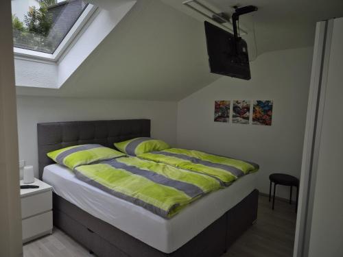 a bedroom with a bed with yellow sheets and a television at Ferienwohnung Ausblick in Bad Wildbad