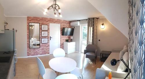 a living room with a white table and chairs at APARTAMENTY NA PLAŻY - KRUKlanki in Kruklanki