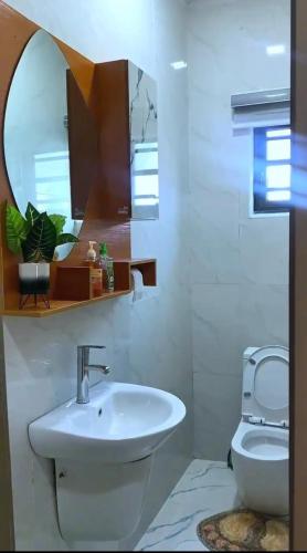 een badkamer met een wastafel, een toilet en een spiegel bij 3 bedroom apartment, Ikate in Lekki