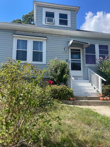 a gray house with a white door and some bushes at Chic City apartment in Providence in Providence