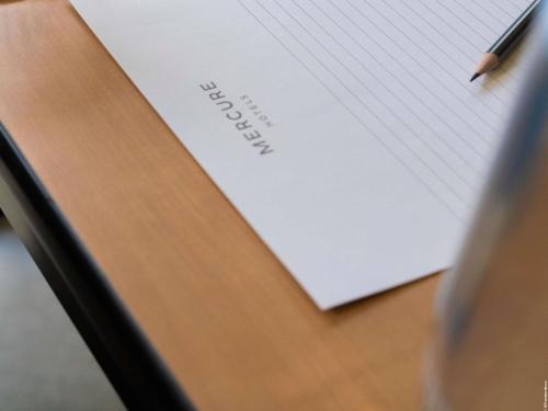 a piece of paper on a desk with a pen at Mercure Bordeaux Lac in Bordeaux