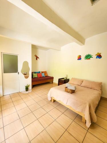 a bedroom with a bed and a couch at Habitaciones Casa Bule in Oaxaca City