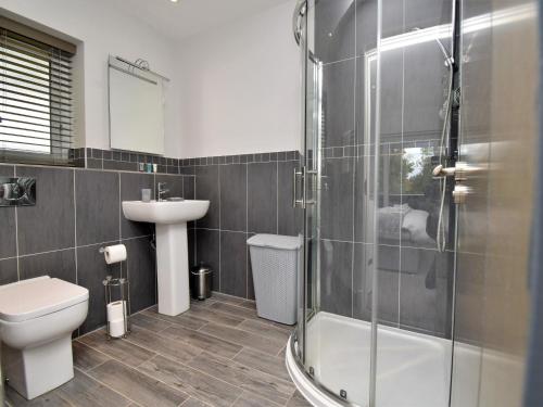 a bathroom with a shower and a toilet and a sink at 4 Bed in Oswestry 75175 in Kinnerley