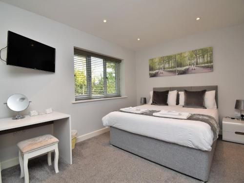 a bedroom with a bed and a desk and a television at 4 Bed in Oswestry 75175 in Kinnerley