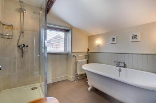 bagno con ampia vasca e doccia di Holly Cottage a Cromer