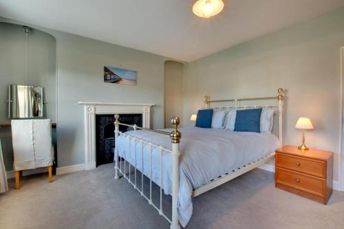 una camera da letto con un letto con cuscini blu e un comò di Holly Cottage a Cromer