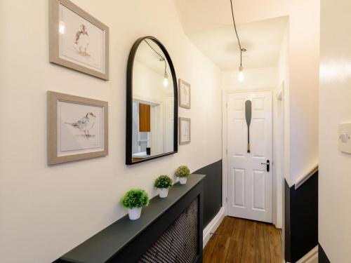 a hallway with a mirror and a black counter with plants at 2 Bed in Appledore 63084 in Appledore
